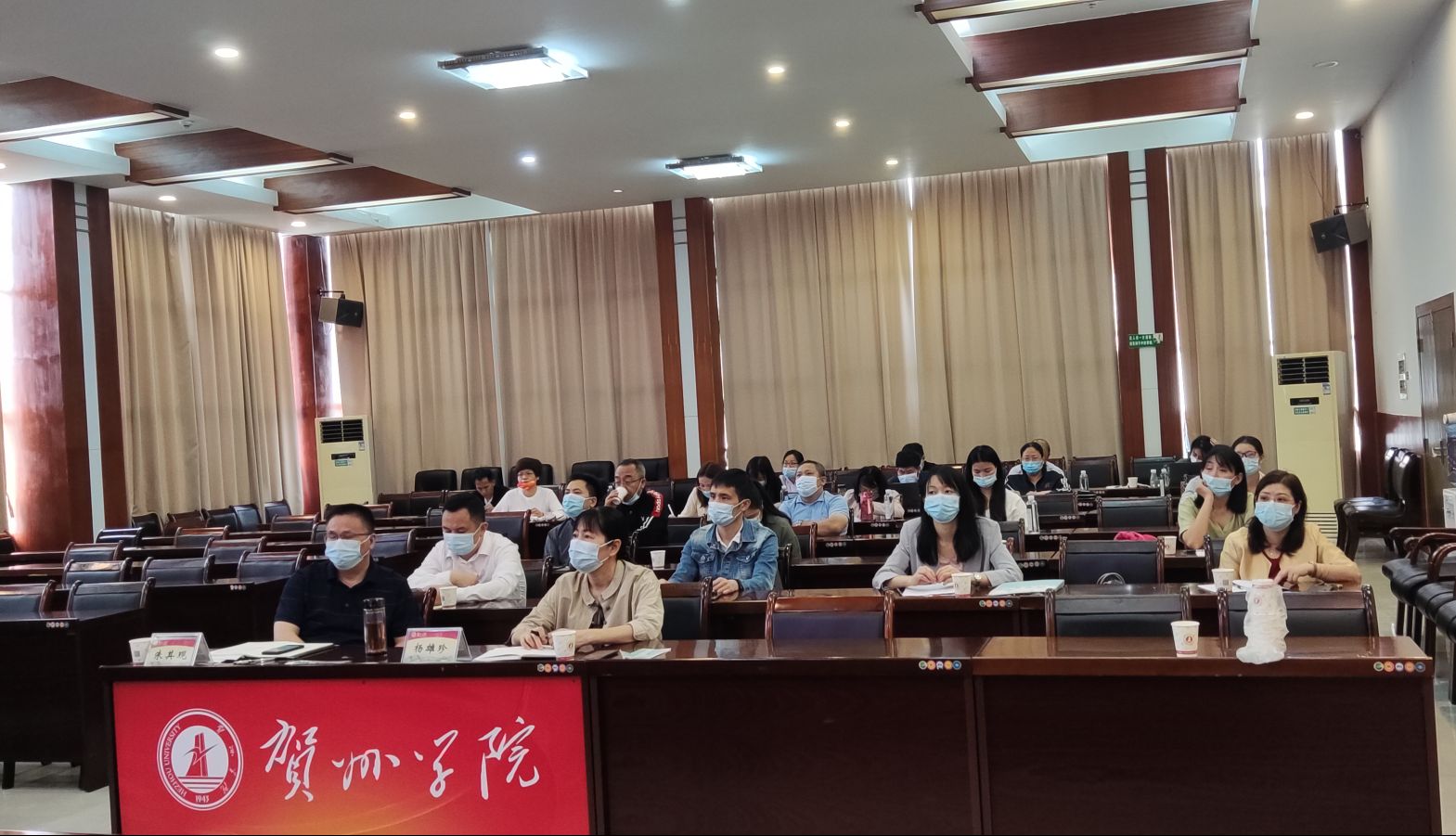 图为学校相关人员认真听取报告